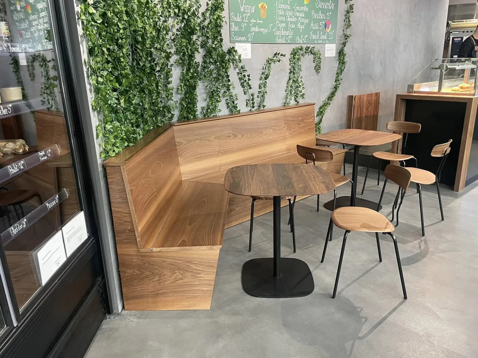 La banquette installee devant le mur végétal, tables et tabourets